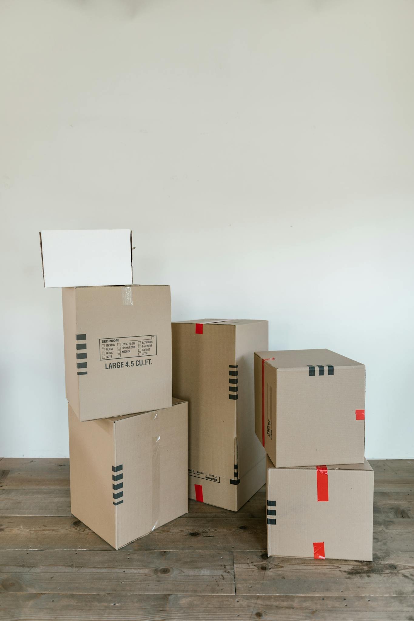 A stack of various cardboard boxes ready for moving or shipping indoors.